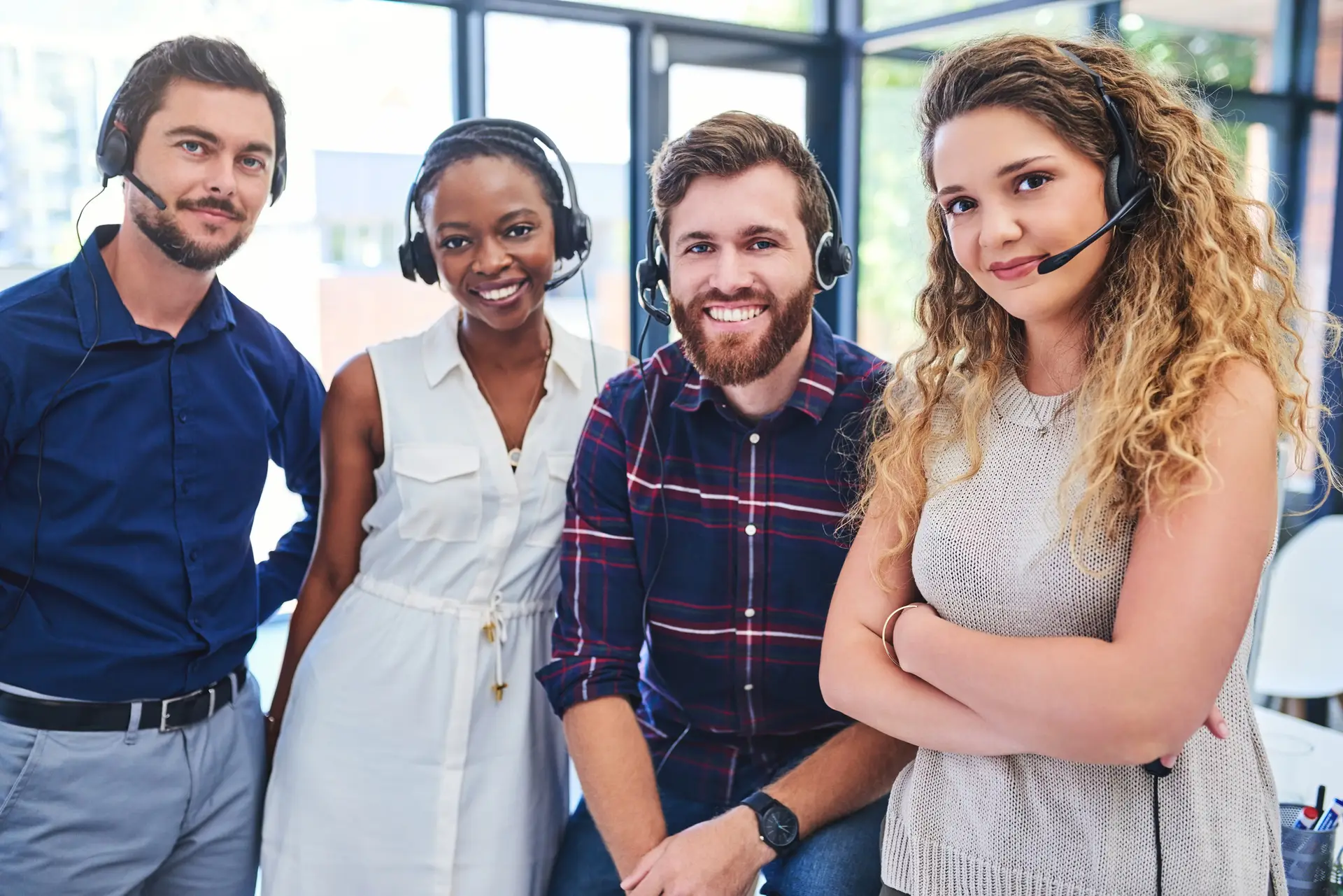 Portrait of a team of confident young people working together in a call centre