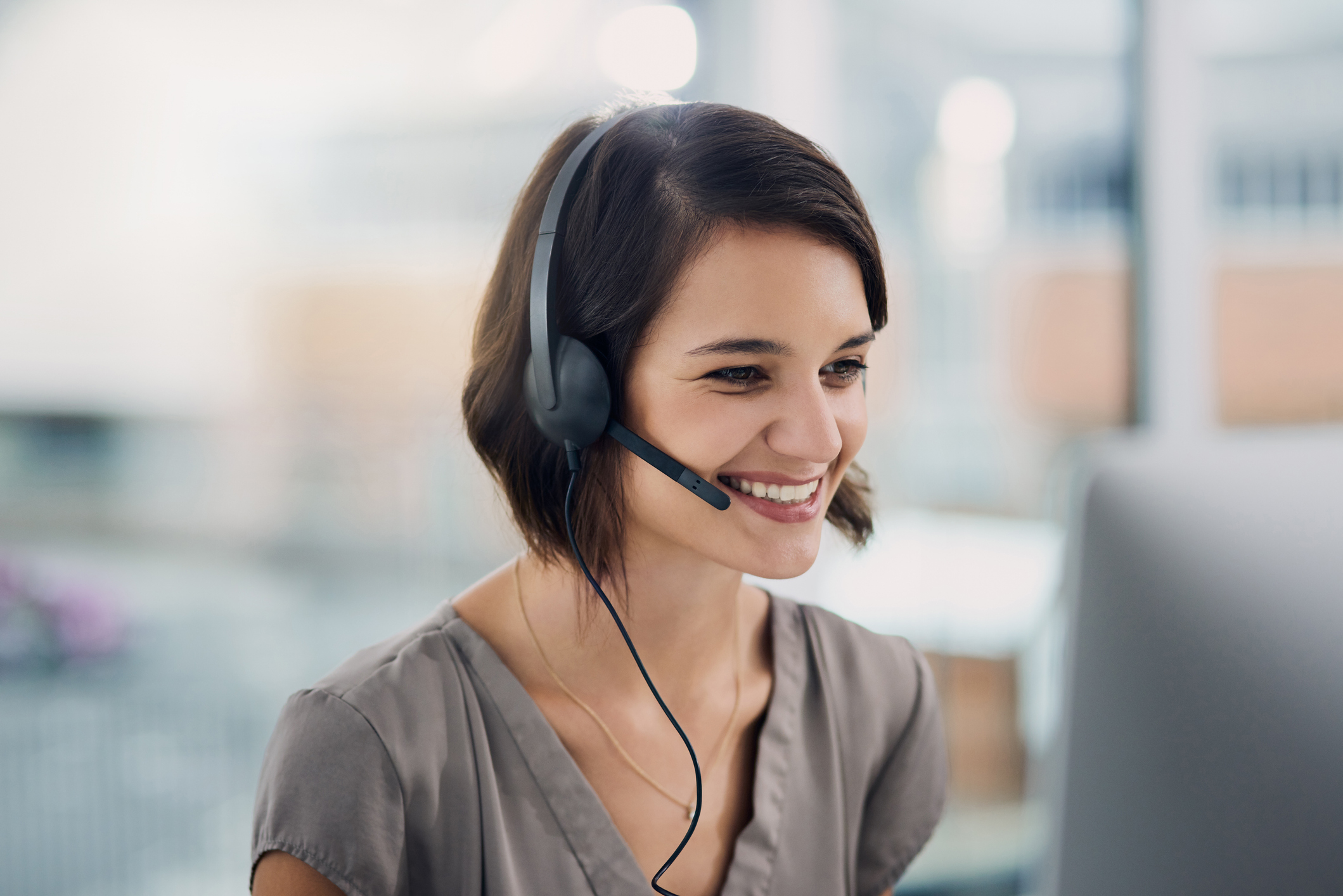 Cropped shot of an attractive young woman using a headset while sitting at her desk in the office