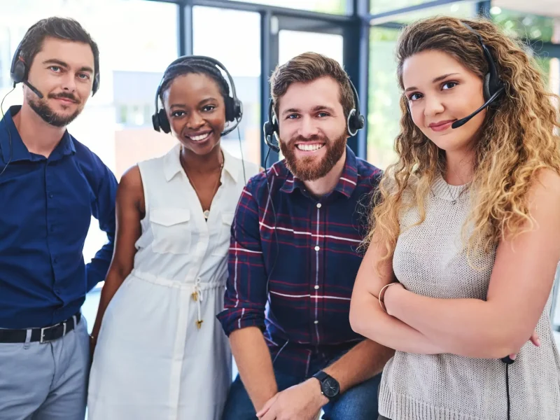 Portrait of a team of confident young people working together in a call centre