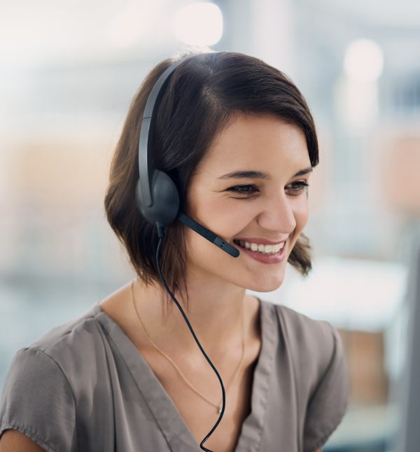 Cropped shot of an attractive young woman using a headset while sitting at her desk in the office