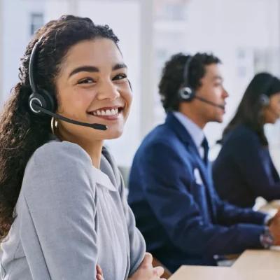 Call center woman, happy and portrait at help desk, job and staff group with computer, advice and office. Telemarketing agent, pc and microphone with headphones, consulting or listen for tech support
