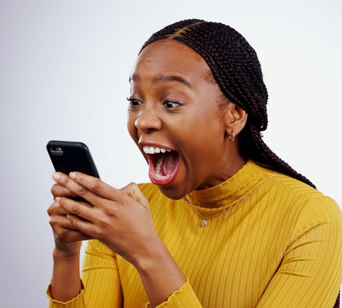 Woman, reading phone and wow for happy news, social media competition or giveaway success on a white background. African person with surprise, excited and shocked for mobile sale or bonus in studio