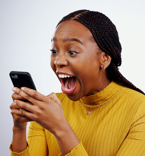 Woman, reading phone and wow for happy news, social media competition or giveaway success on a white background. African person with surprise, excited and shocked for mobile sale or bonus in studio