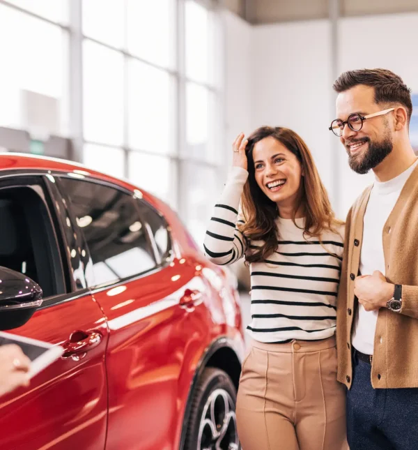 Car salesman discussing contract with couple